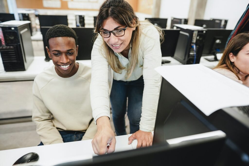 Teacher working with students inside computer class room - Focus on woman face