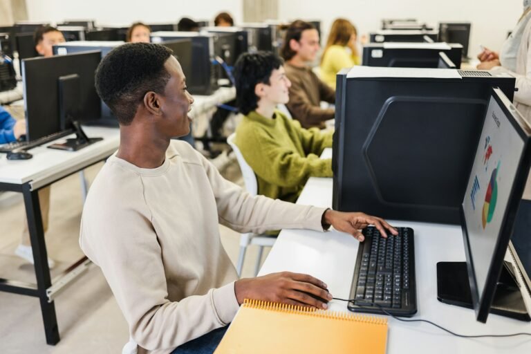Young african student using computer inside college room at school university - Focus on face