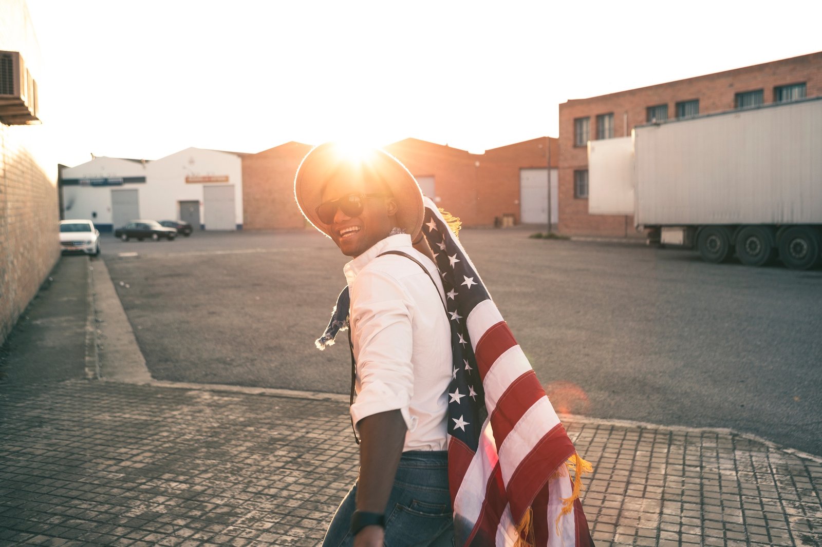Laughing young man with American flag at backlight